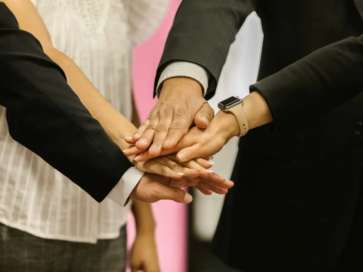 Colleagues joining hands as a team