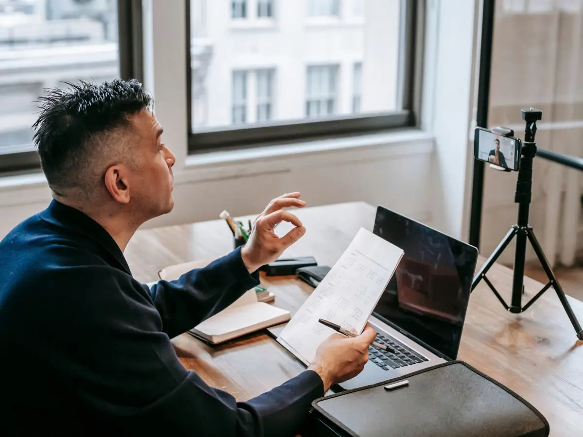 Man on a video call with laptop and phone