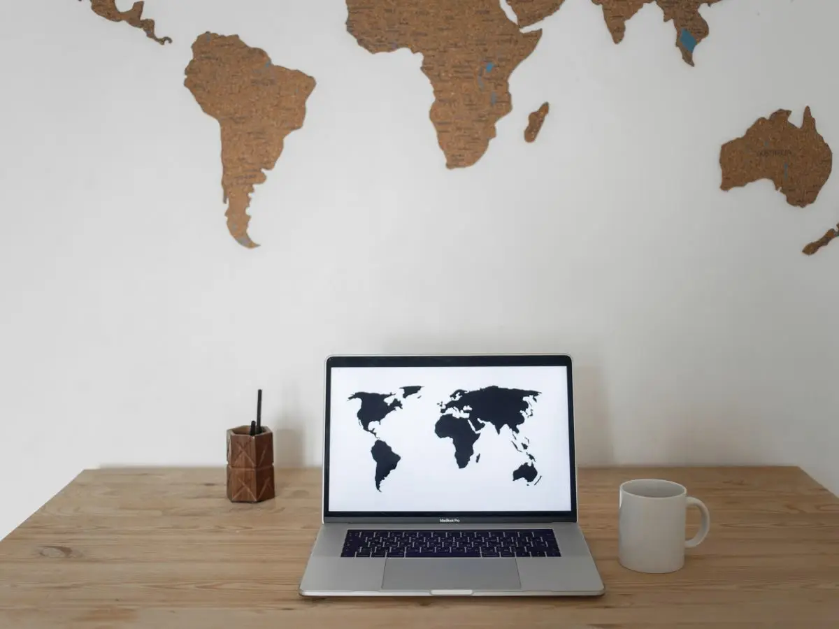 Desk with a laptop showing a world map