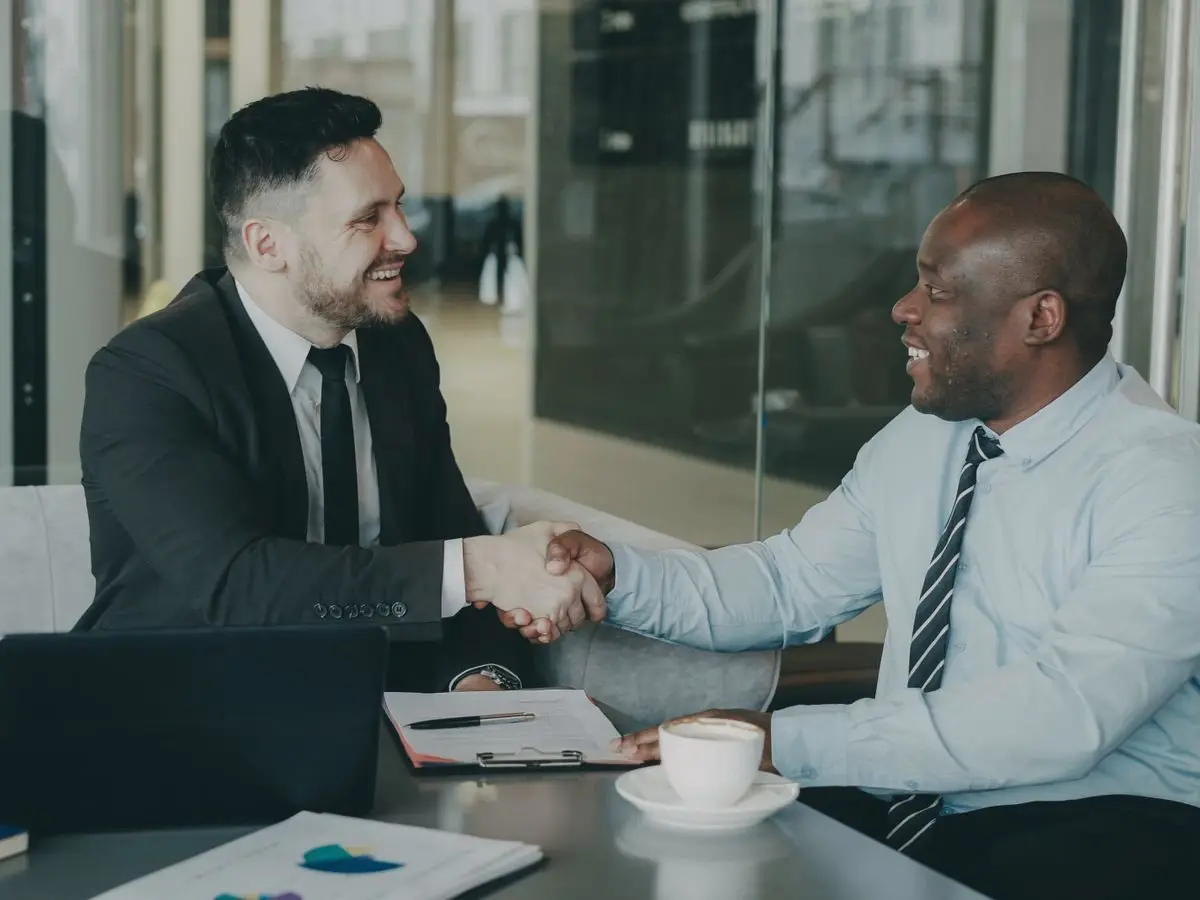 Two businessmen shaking hands over a deal