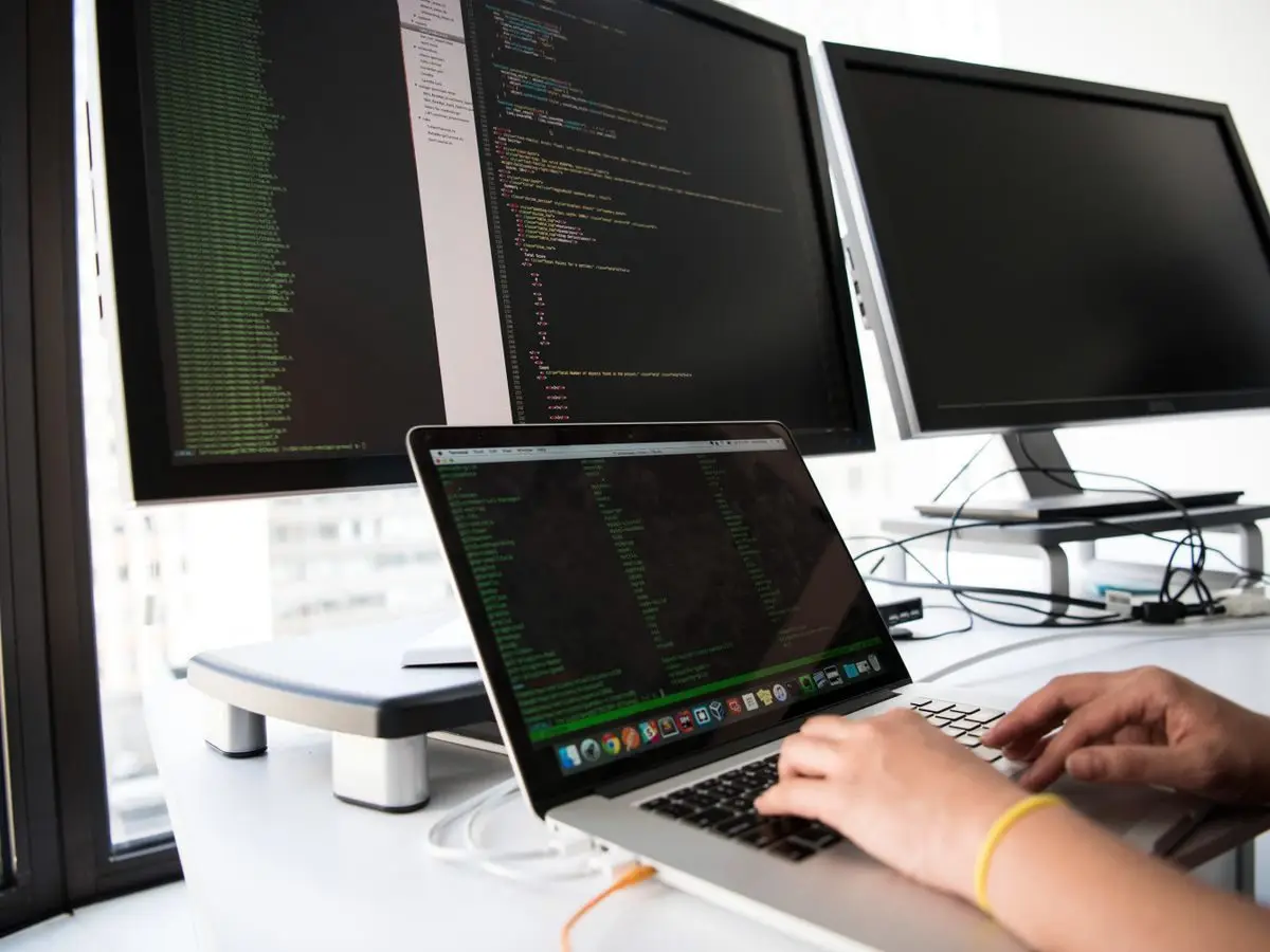 Developer coding in front of multiple monitors
