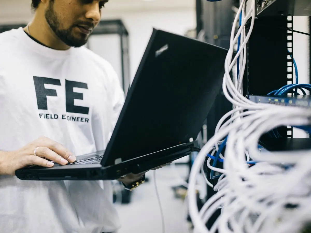 Engineer working on network hardware in a server room
