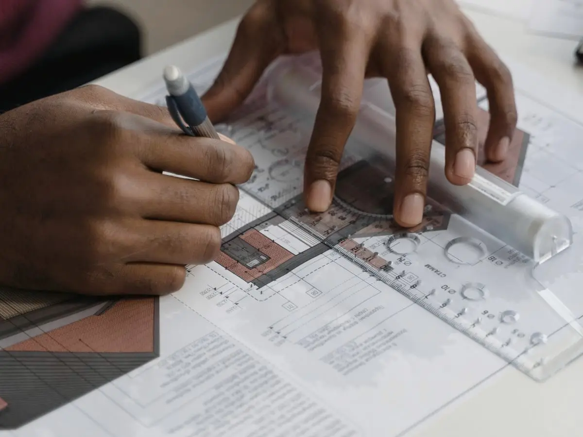 Hands drawing a blueprint
