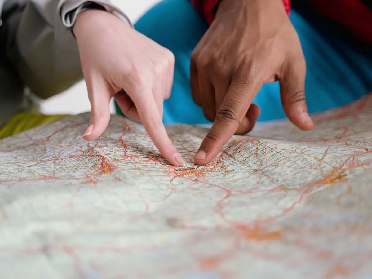 Hands pointing at a route on a map