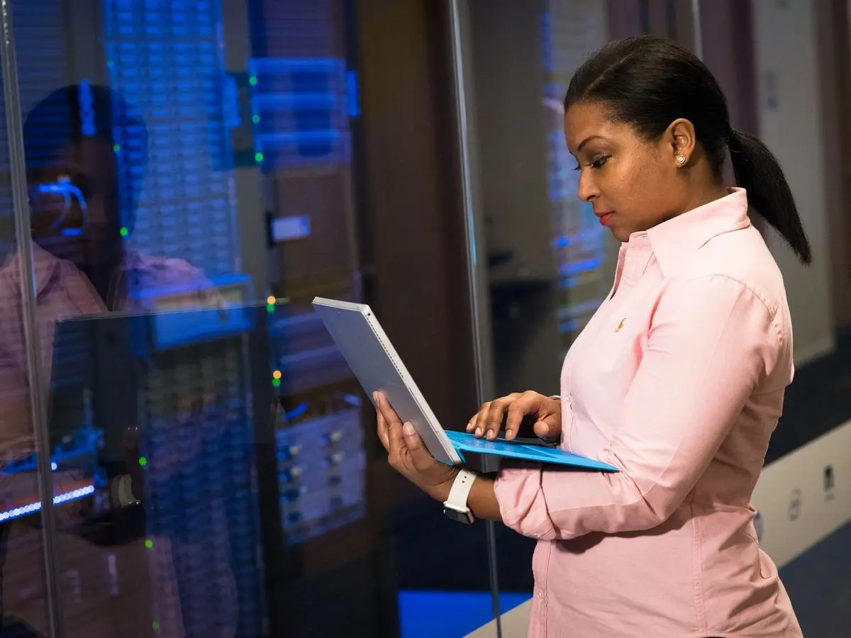 An IT engineer working on a laptop in a server room