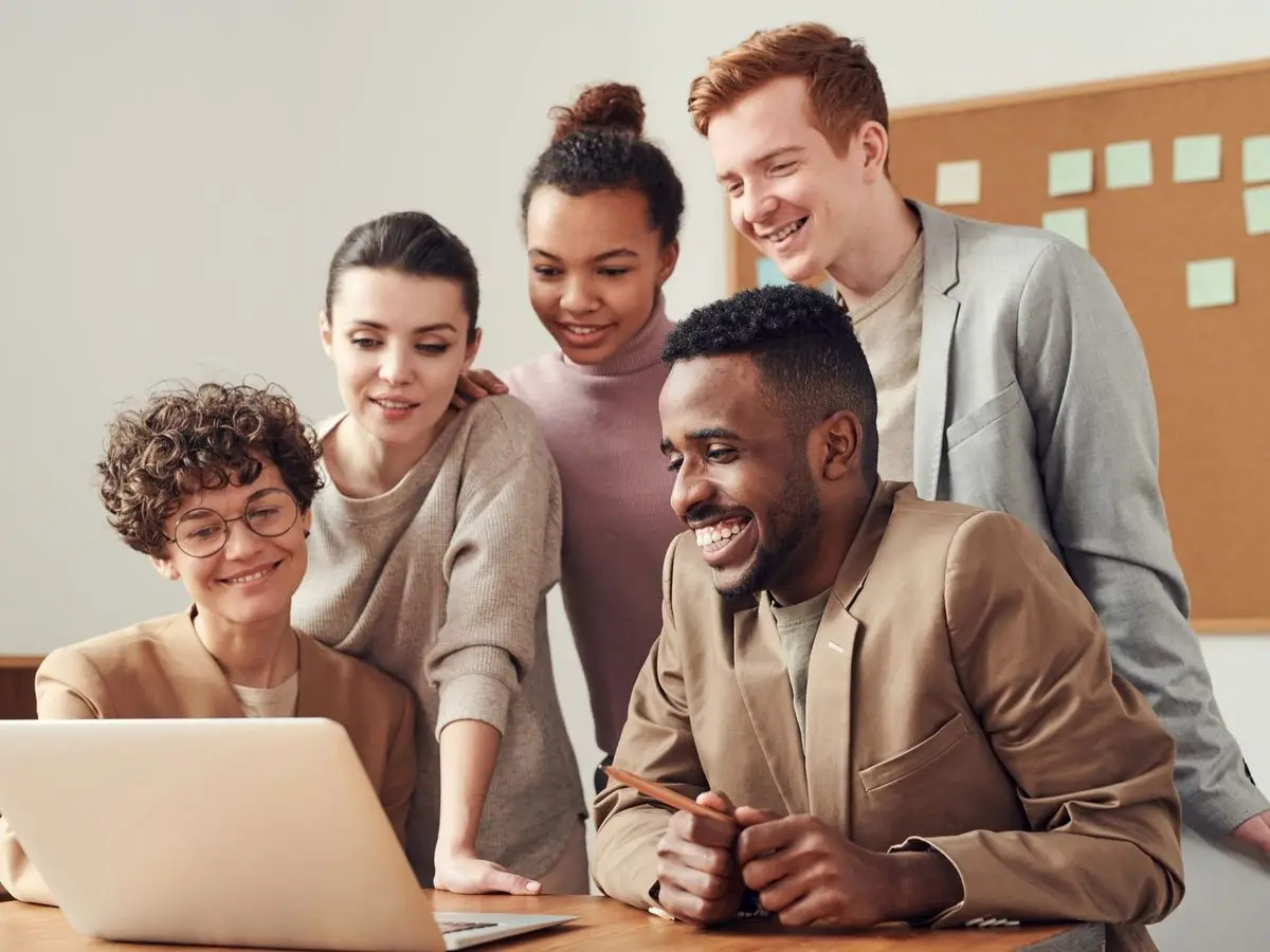 Colleagues smiling at content on a laptop screen