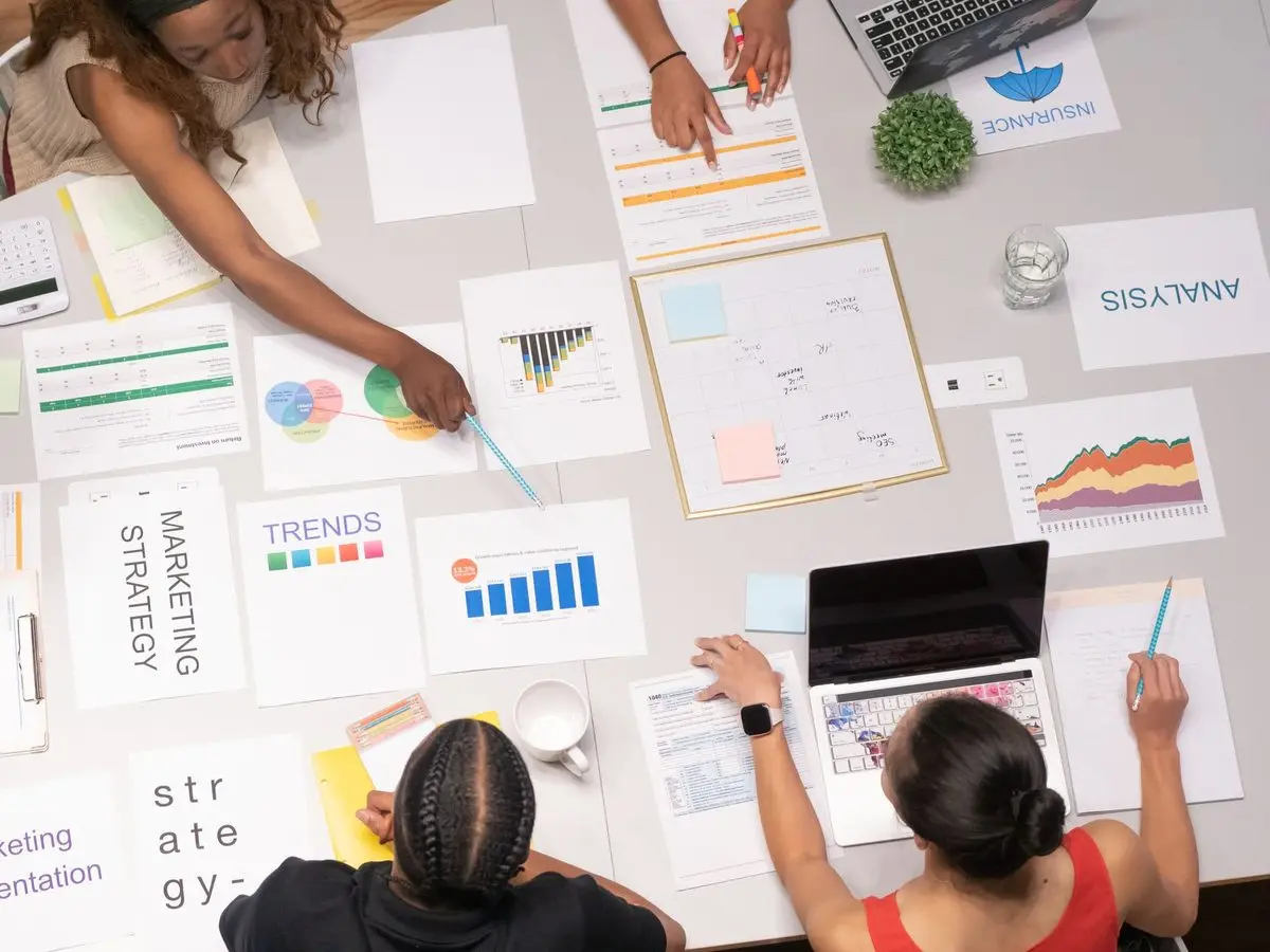 Marketing team planning a campaign with charts on a table
