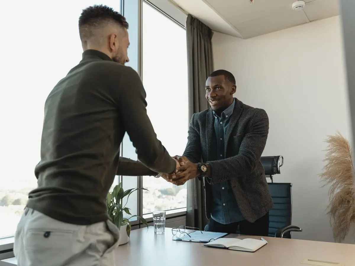Two business people shaking hands in an office