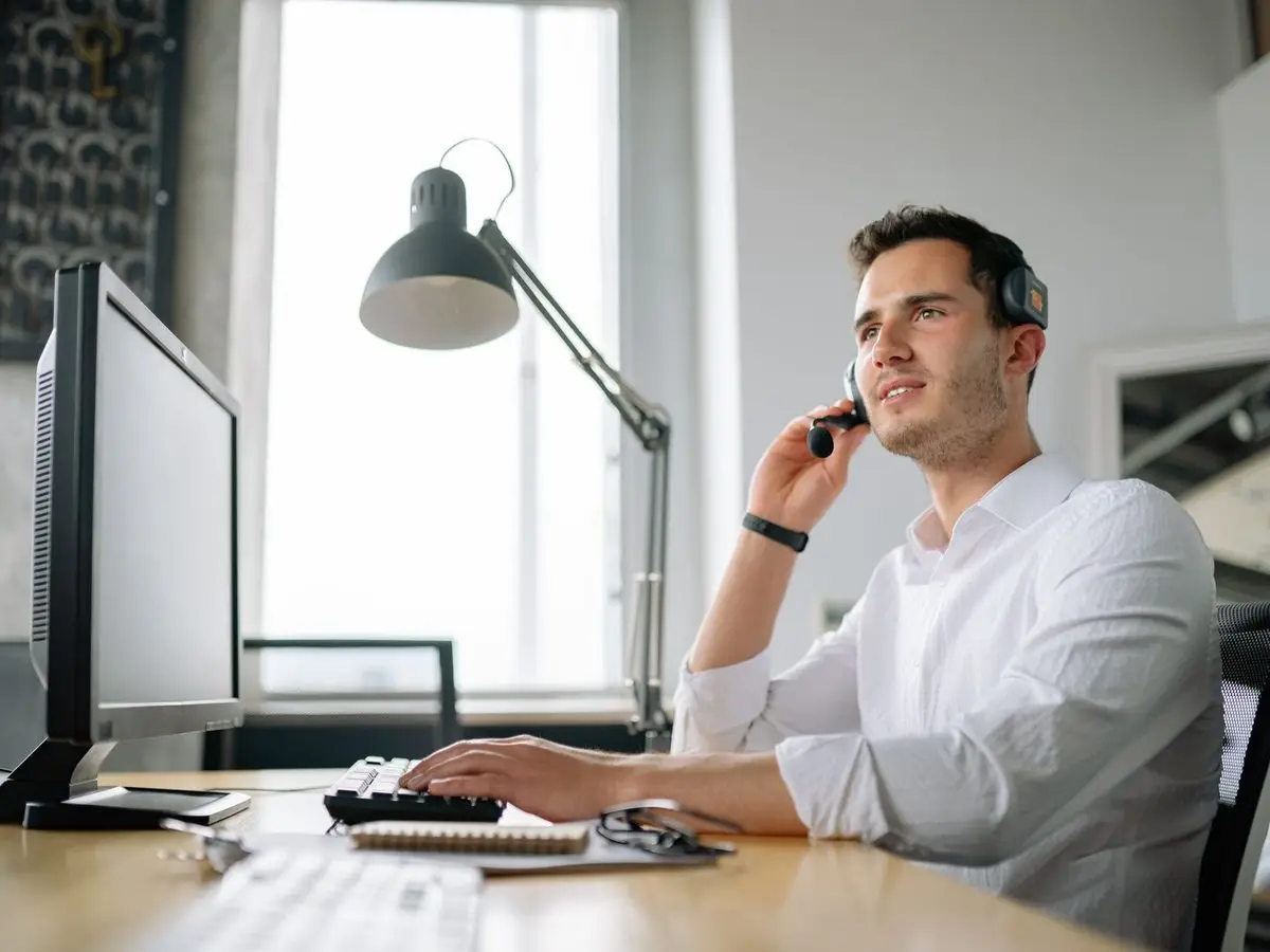 Support analyst on a call at his desk