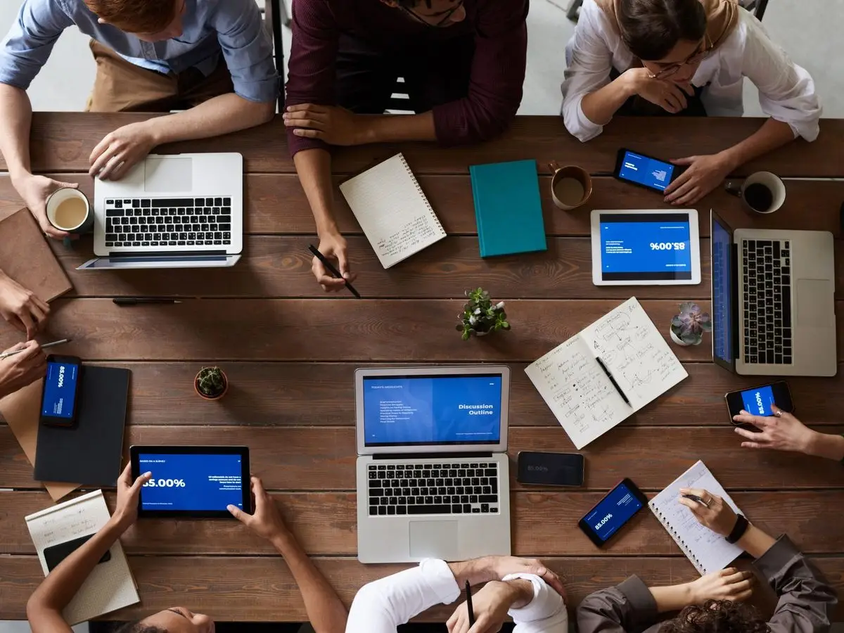 Team working with laptops, tablets and phones on one table