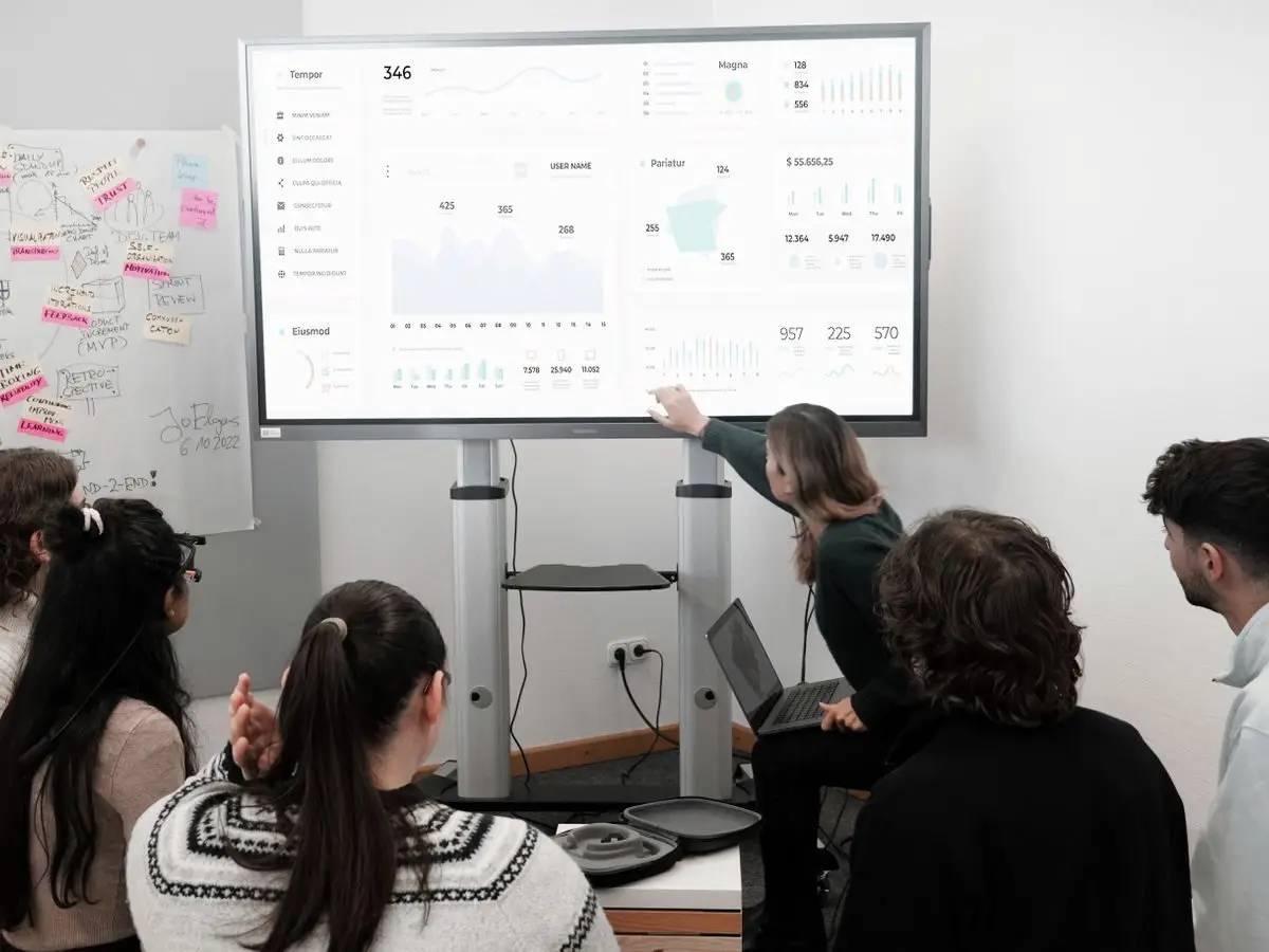 Team examining charts on a large screen