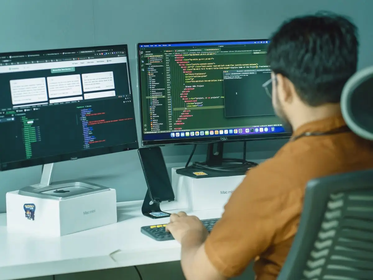 Developer coding on dual monitors