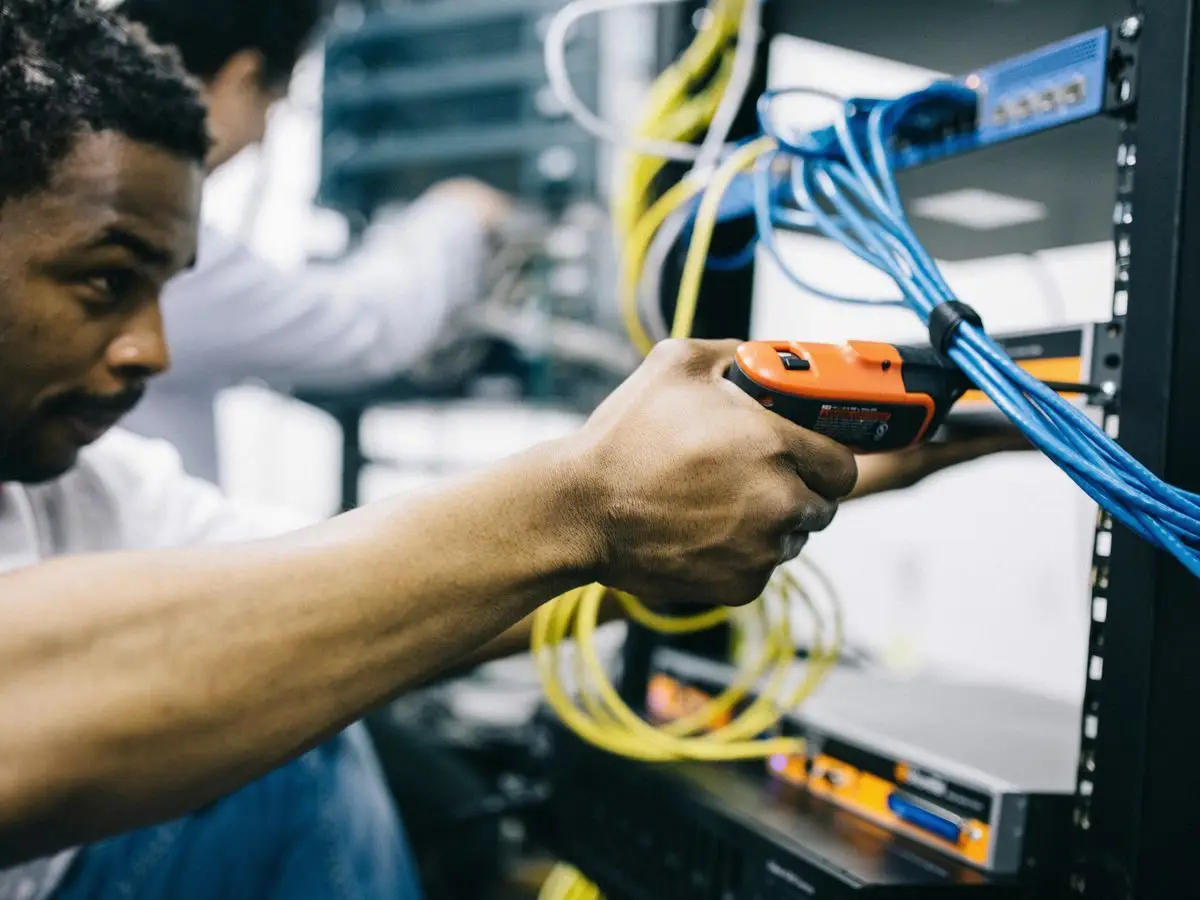 Engineer checking network cables in a server room