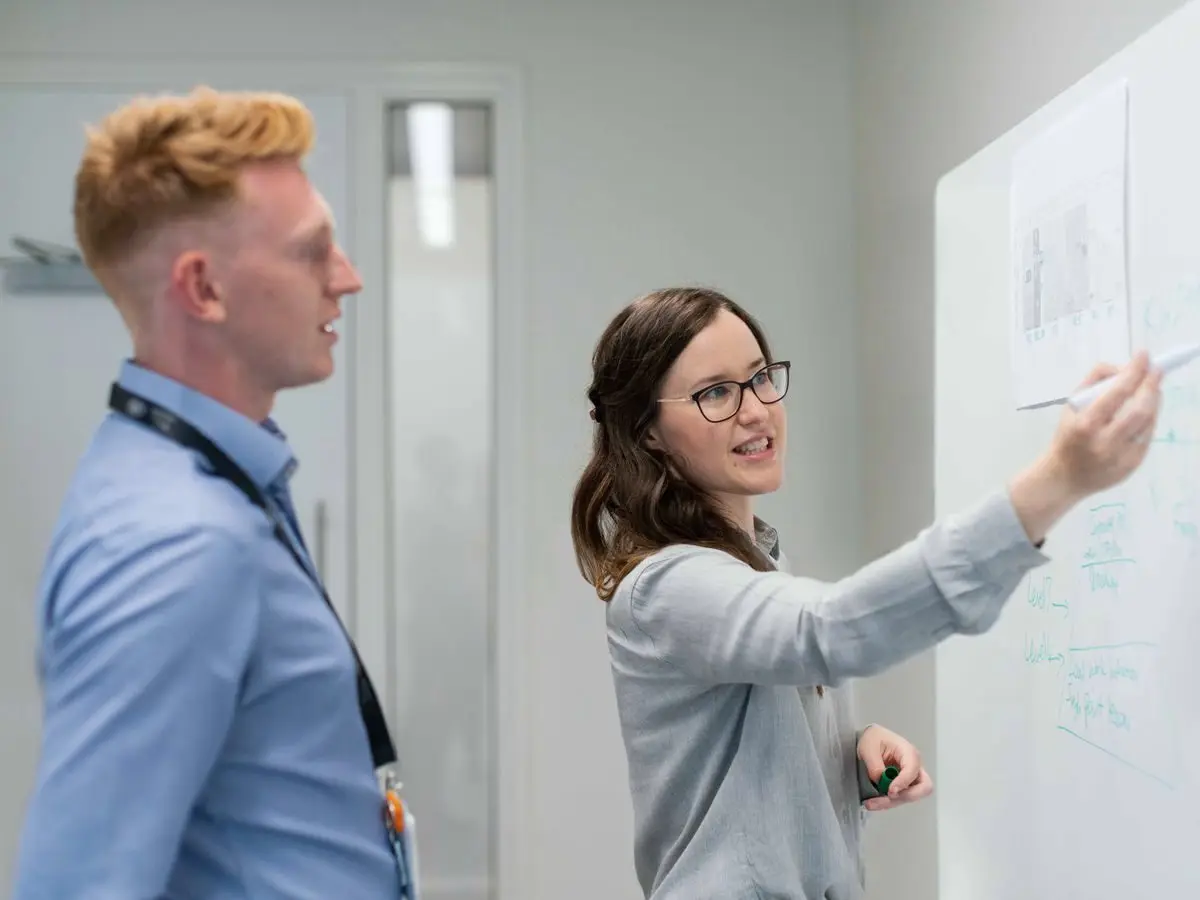Colleagues discussing at a whiteboard